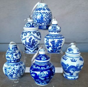 Collection of blue and white porcelain ornaments with traditional Asian patterns, including florals and dragons, representing David Watkins Designs' affinity for classic and cultural decor elements.